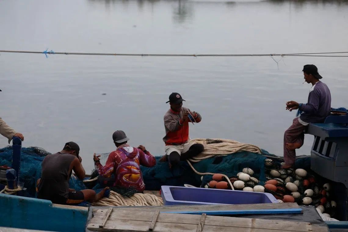 Fishermen clean their nets after returning from the sea at the Lampulo Traditional Fishing Port in Banda Aceh, Indonesia, on May 18. -- PHOTO: EPA via The Straits Times-ANN