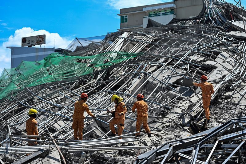 Five people were confirmed trapped, including two in contact with rescuers, and 18 more were feared under the rubble, officials said.