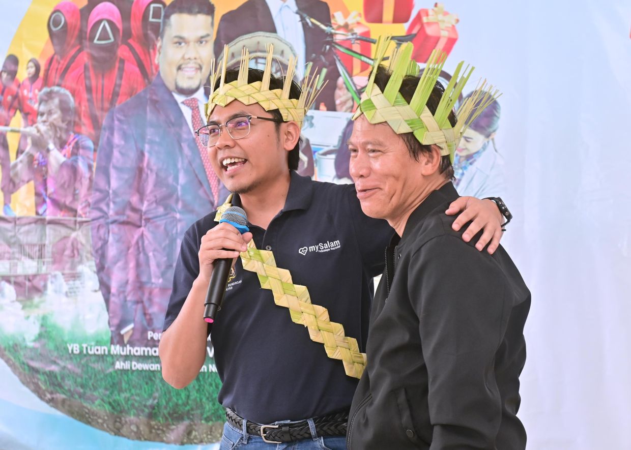 SYUHAIB Ithnin (left) with veteran artiste Helmi Gimmick, who is also a beneficiary of mySalam, at the 3K Carnival in the Community Hall of the Makmur Orang Asli Village in Hulu Kinta.