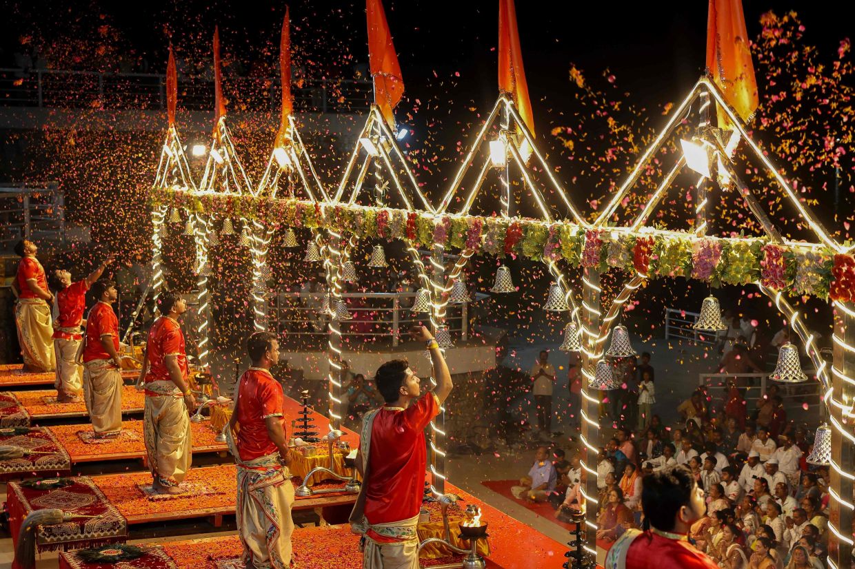 Hindu priests perform evening prayers at Namo Ghat along the banks of the river Ganges in Varanasi. -- Photo by Niharika KULKARNI / AFP