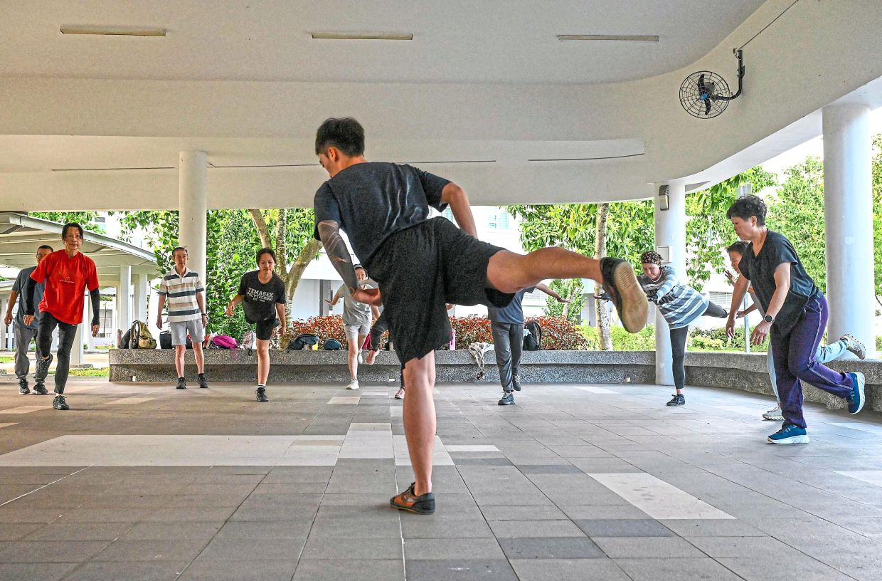 How it’s done: Coach Tan leading a warm-up session. — AFP 