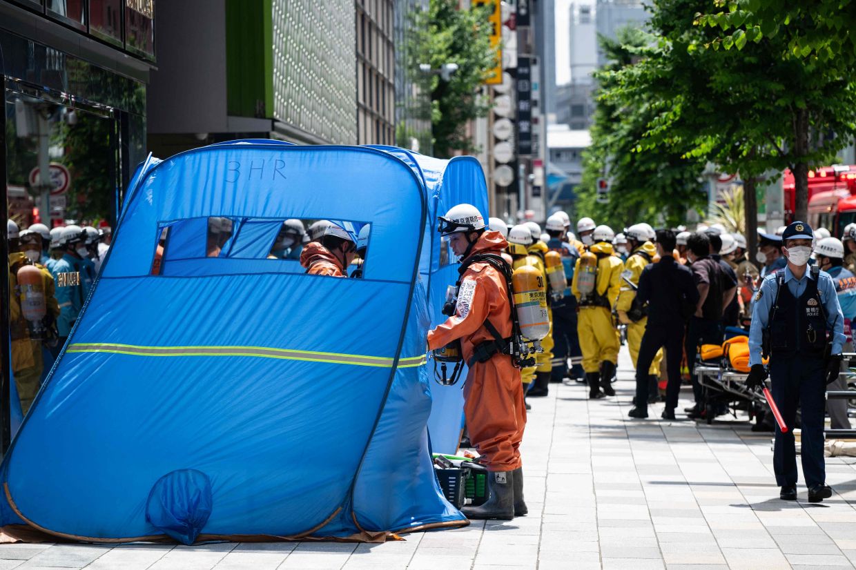 Emergency personnel seen in front of the Ginza 6 Shopping Centre after an individual allegedly sprayed a substance at an ATM inside the mall. - AFP