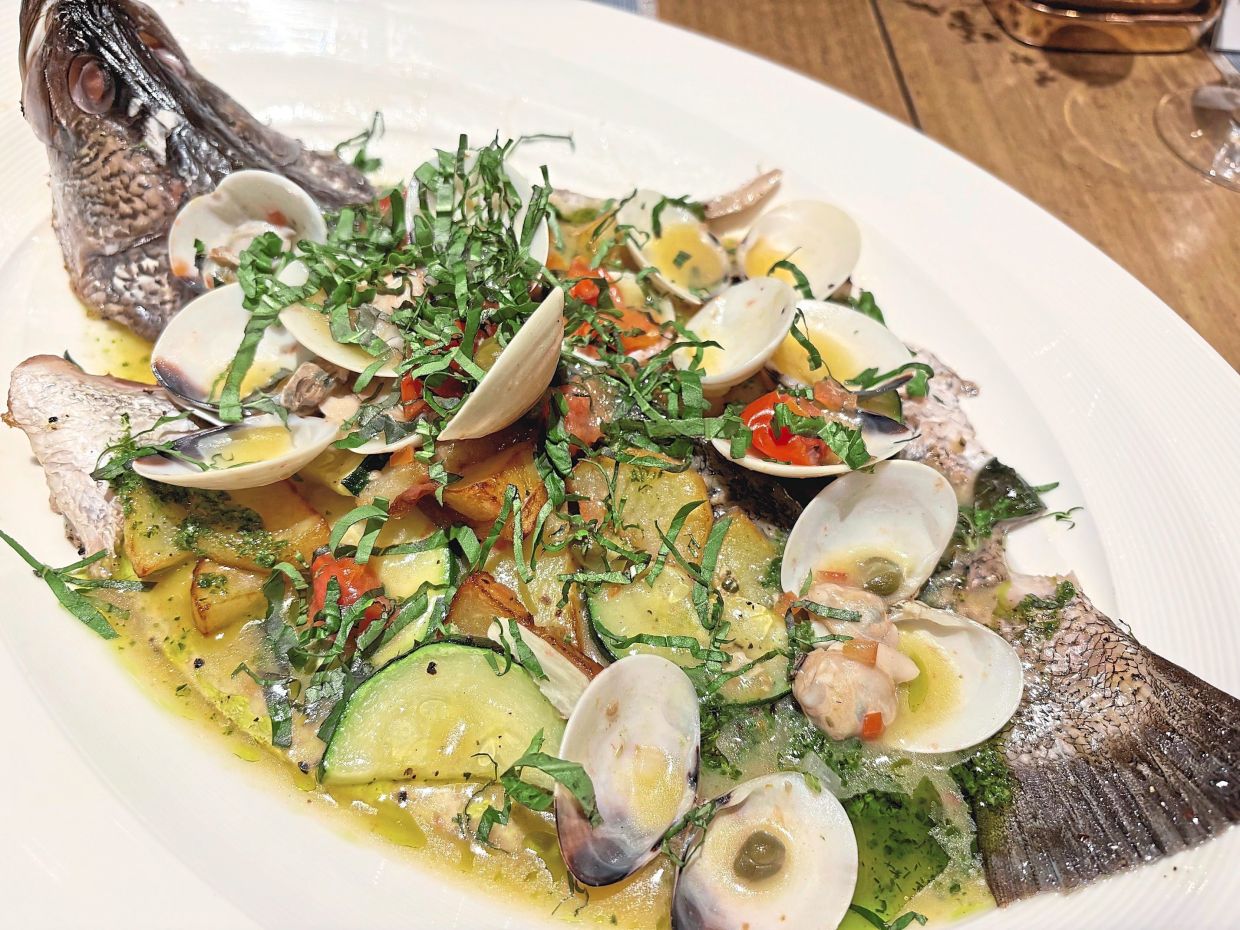 Whole Oven-Baked Seabass with clams, capers and cherry tomatoes.