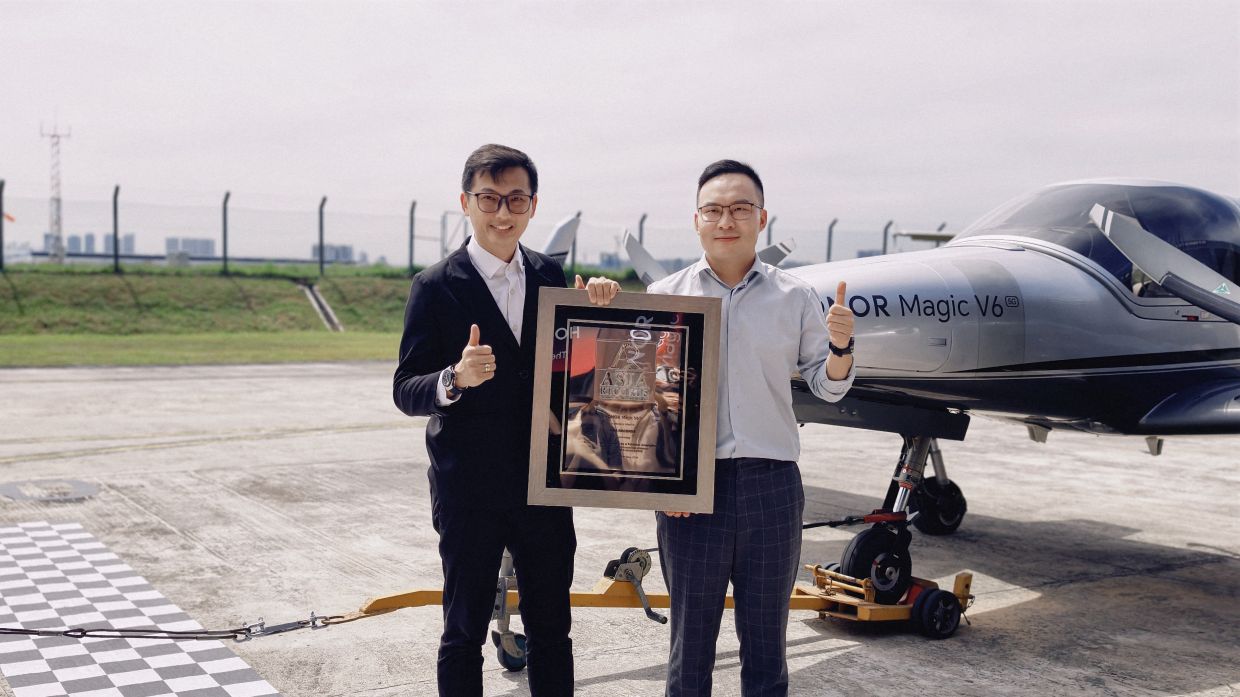 From left: ASIA Records chief adjudicator Eldrick Koh presenting the ASIA Records certificate for “Heaviest Aircraft Towed by a Foldable Smartphone” to HONOR Malaysia deputy country director Ethan Chen. The HONOR Magic V6 towed a Diamond DA42 Twin Star aircraft 150m, setting the Asia Record for Heaviest Aircraft Towed by a Foldable Smartphone.