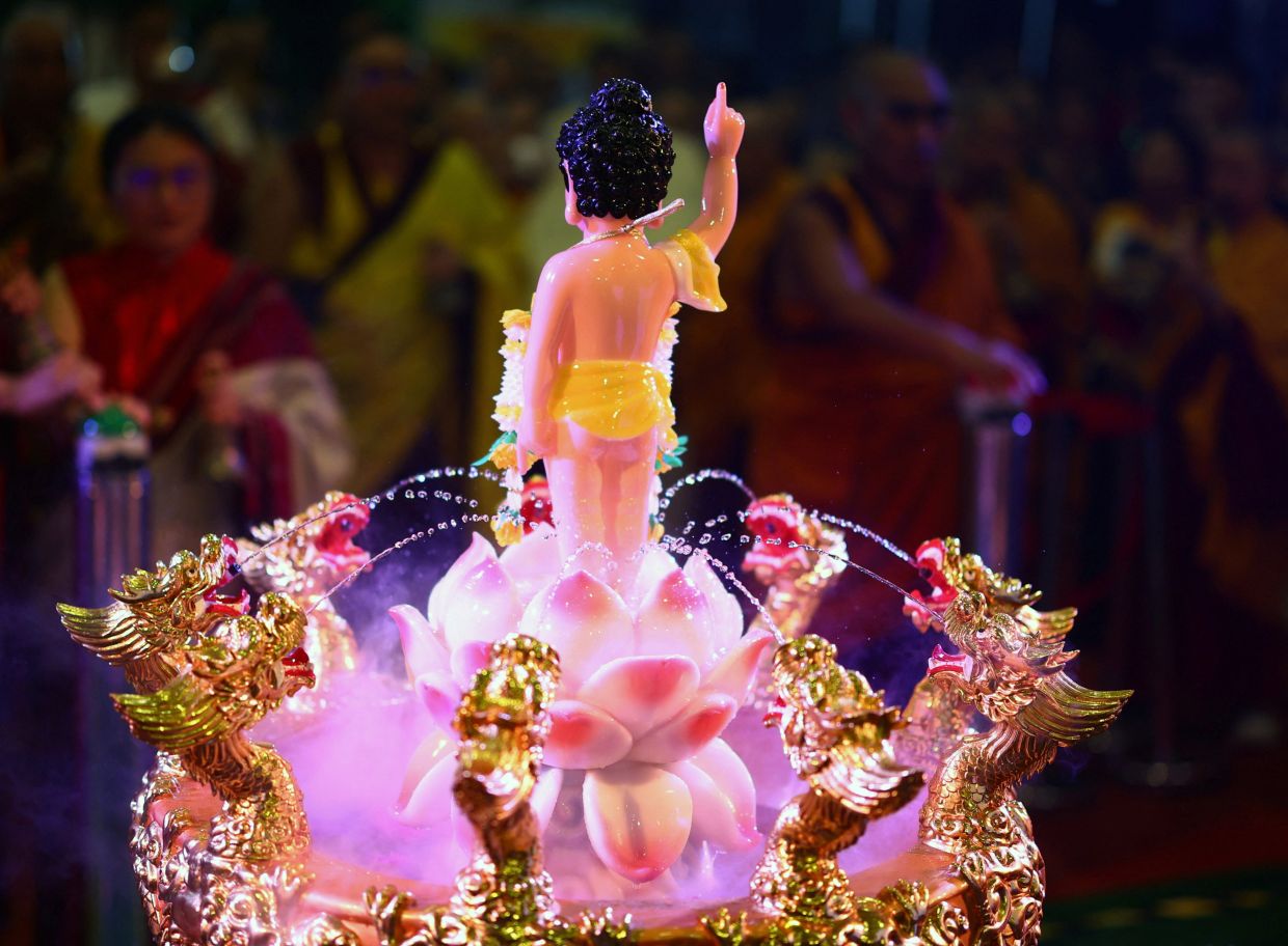 Devotees perform a Buddha bathing ritual during Vesak Day celebrations organised by the Tibetan Buddhist temple Thekchen Choling, in Singapore. - Photo: REUTERS/Edgar Su