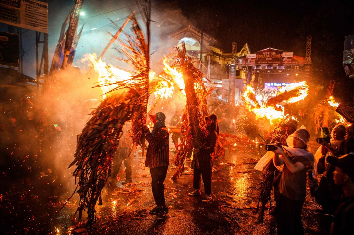 Participants strike each other with lit torches made of dried coconut leaves during the traditional Perang Obor (Torch War) ritual, held to celebrate a rich harvest, in Tegalsambi, Central Java. -- Photo by DEVI RAHMAN / AFP