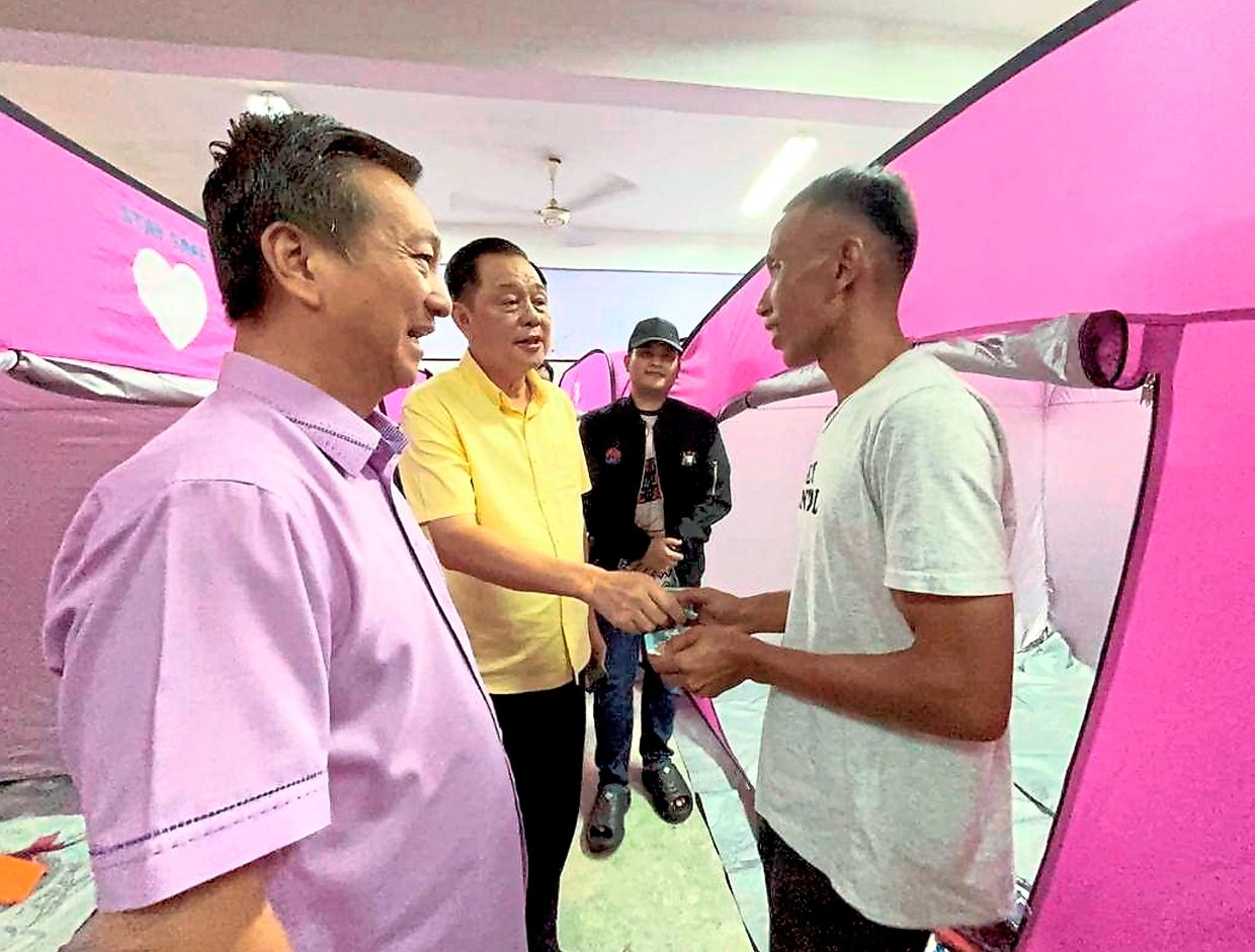 Eng Meng (second from left) handing out financial aid to storm victims in his constituency while Tanjung Piai MP Datuk Seri Dr Wee Jeck Seng (left) looks on. — Courtesy of Tan Eng Meng’s Facebook page