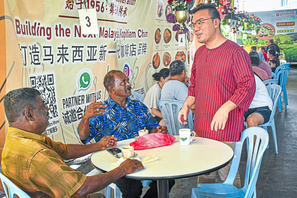 Kan with the bottles of coffee helping to promote Klang.
