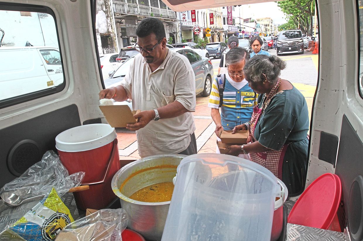 Left: Jayaraman (left) dishing out vegetarian food for the public near Goddess of Mercy Temple in Jalan Masjid Kapitan Keling.