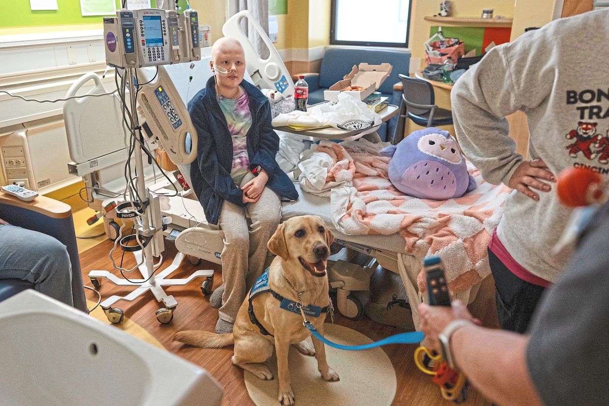 Hadley sitting by tween Bethany, who recently finished a chemotherapy treatment session. 