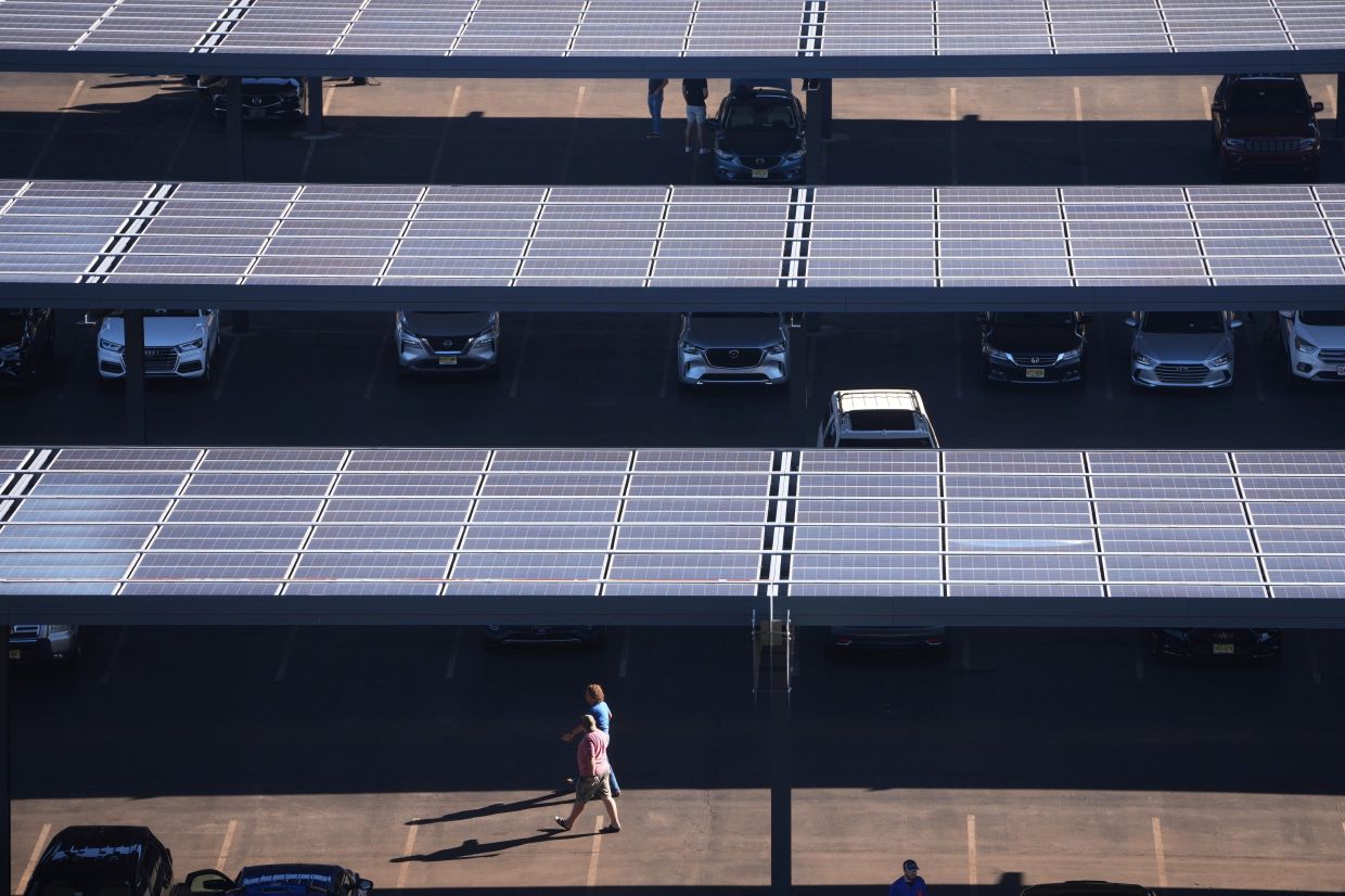People walk though a parking lot with solar panels near Lincoln Financial Field, Sept. 8, 2025, in Philadelphia. — Photo: AP/Matt Slocum