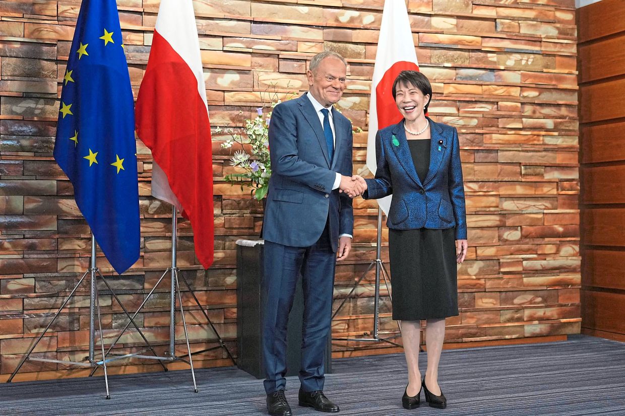 Takaichi (right) shaking hands with Poland’s Prime Minister Donald Tusk before their talks at her office in Tokyo on April 15. Warsaw and Tokyo could cooperate in areas like ­anti-drone and electronic warfare systems, according to a Polish embassy official. — AFP