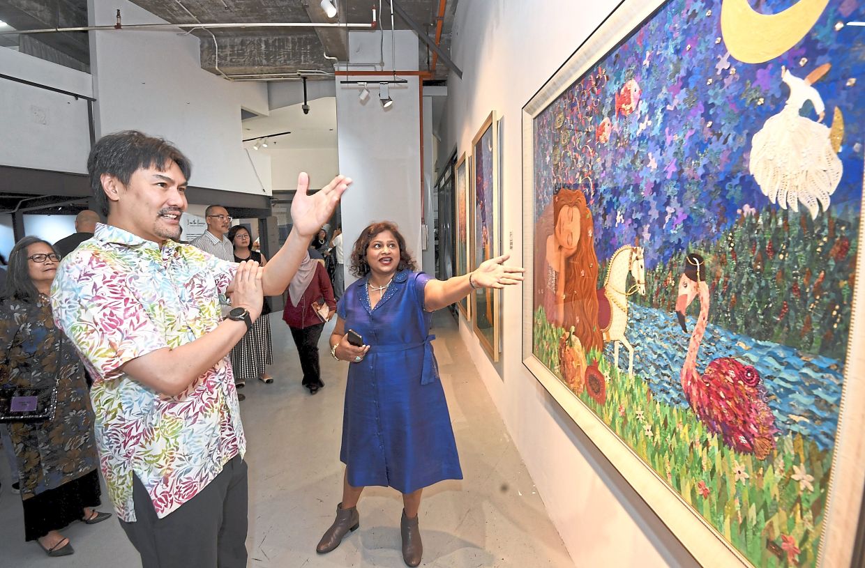 Tulika describing one of her works to Tunku Ali Redhauddin at her solo exhibition.