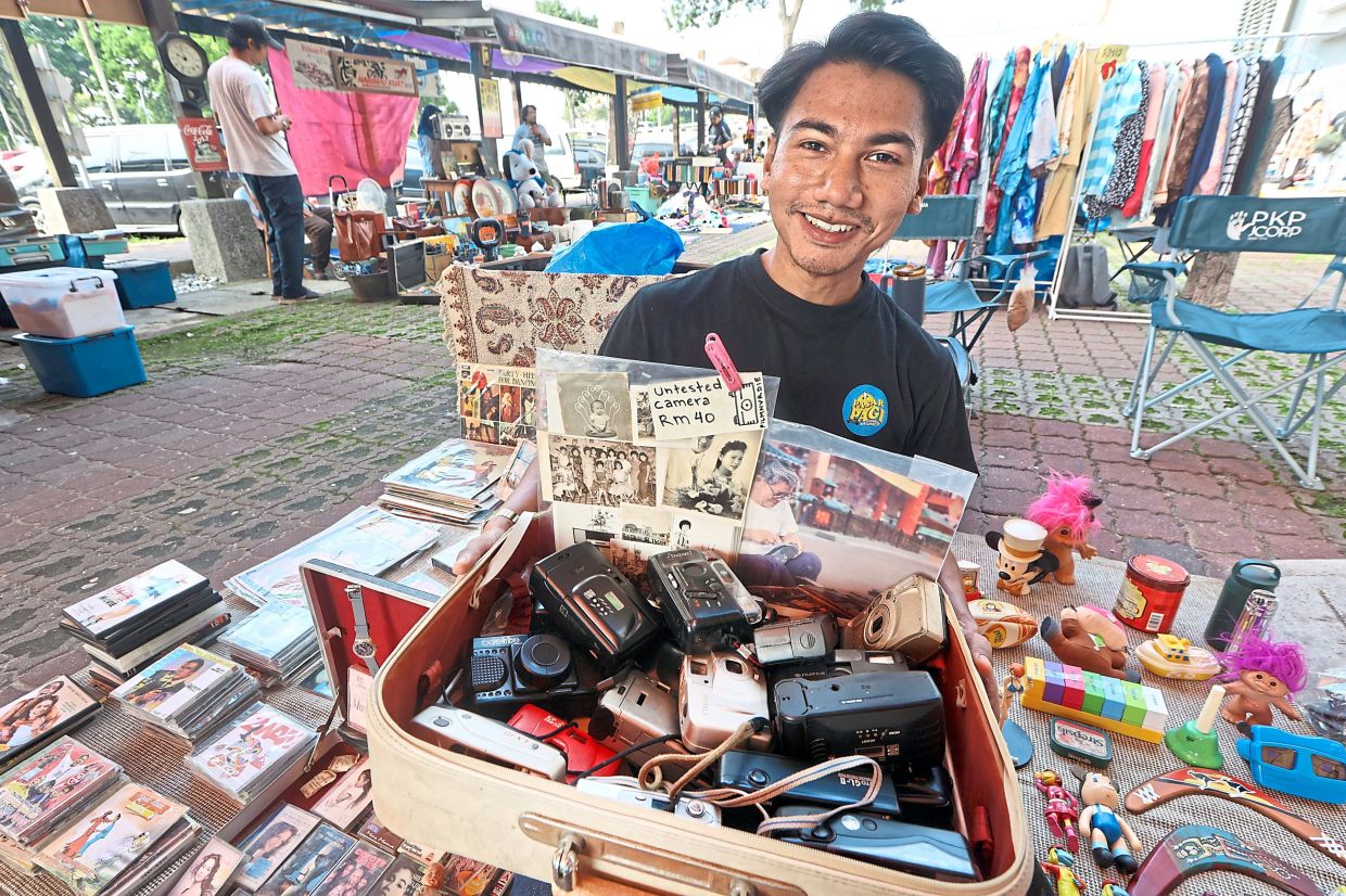 A vendor selling various types of vintage items, including old cameras.