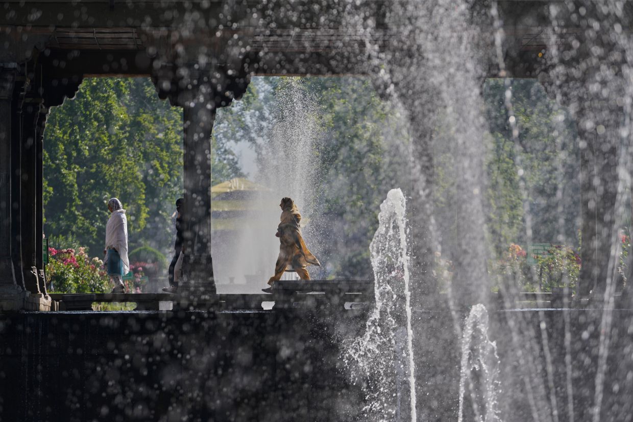 Kashmiri Muslims arrive to offer Eid al-Adha prayers inside a Mughal garden on the outskirts of Srinagar in Indian controlled Kashmir. -- AP Photo/Mukhtar Khan