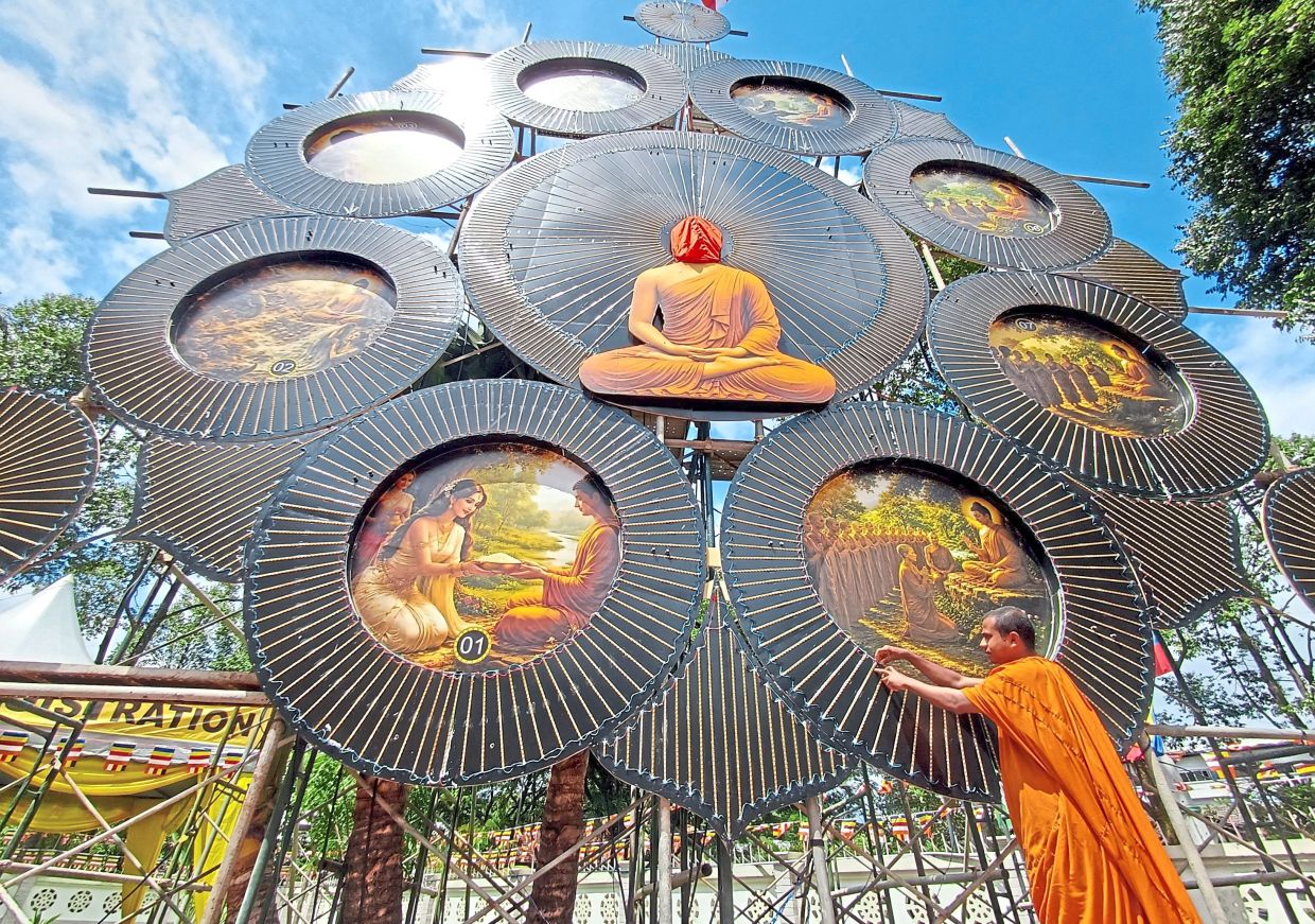 Illuminated reminder: Gnanawimala preparing the giant LED Buddha light board for the Wesak Day celebrations at Buddhist Maha Vihara in Brickfields. — ART CHEN/The Star