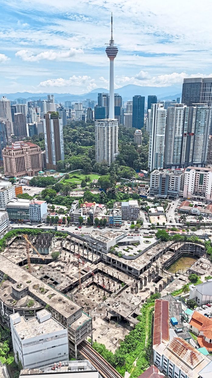 Urban blight: Stagnant rainwater and overgrown vegetation seen at the uncompleted and abandoned Plaza Rakyat project in Kuala Lumpur (foreground). — FAIHAN GHANI/The Star