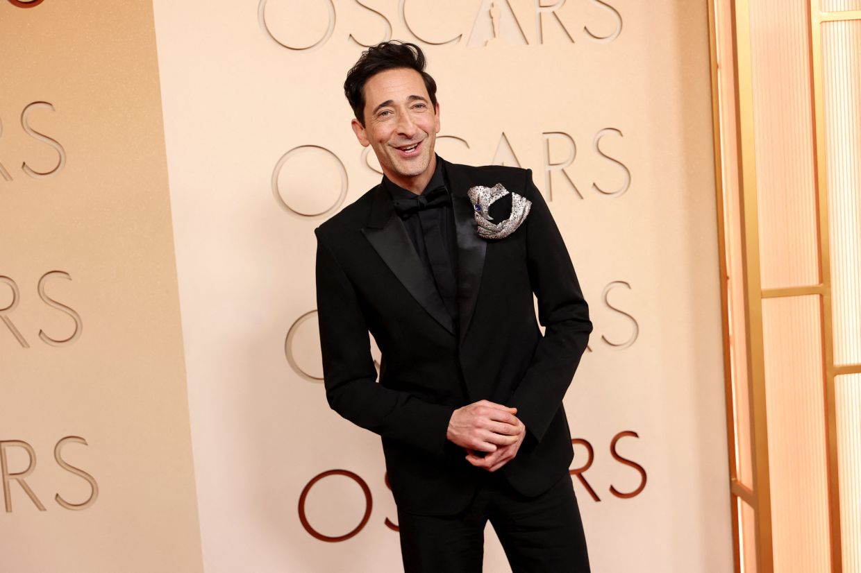 Adrien Brody’s Elsa Jin Studio brooch anchors his more subtle Gucci tuxedo. Photo: Getty Images via AFP