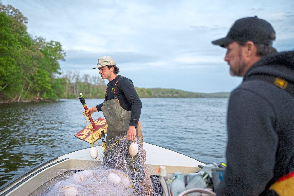 Cole Dobratz (left) and his father, Matt Dobratz, (right) fish for shad on the Connecticut River using traditional methods. — CHRISTOPHER CAPOZZIELLO/ The New York Times
