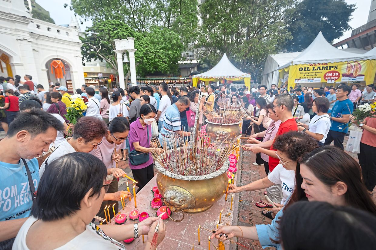 Devotees lighting up lotus candles in Buddhist Maha Vihara in Brickfields, Kuala Lumpur during the 2025 Wesak Day celebration.