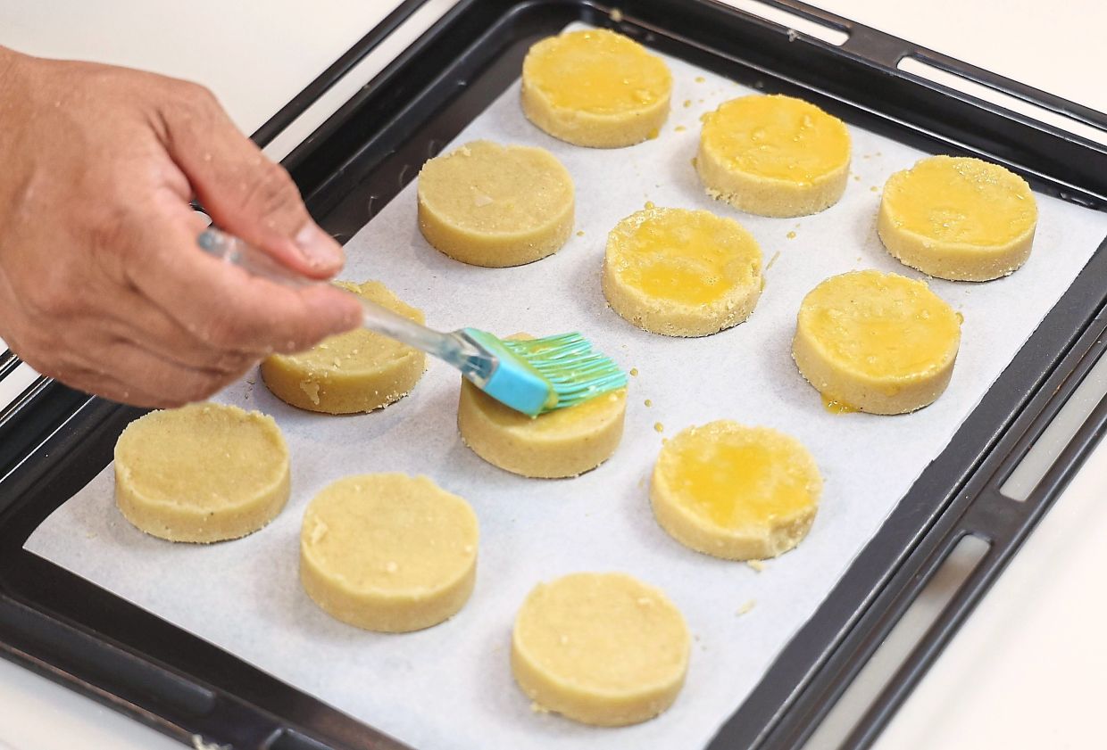 Place the shortbread into a lined baking tray and glaze with eggwash, then garnish with almond flakes