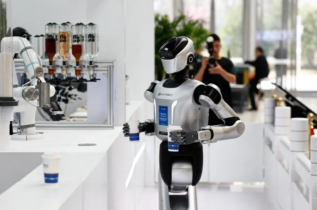 A humanoid robot by Leju Robotics fetching cups of coffee in a demonstration at the 2026 Zhongguancun forum in Beijing on March 25. - Reuters