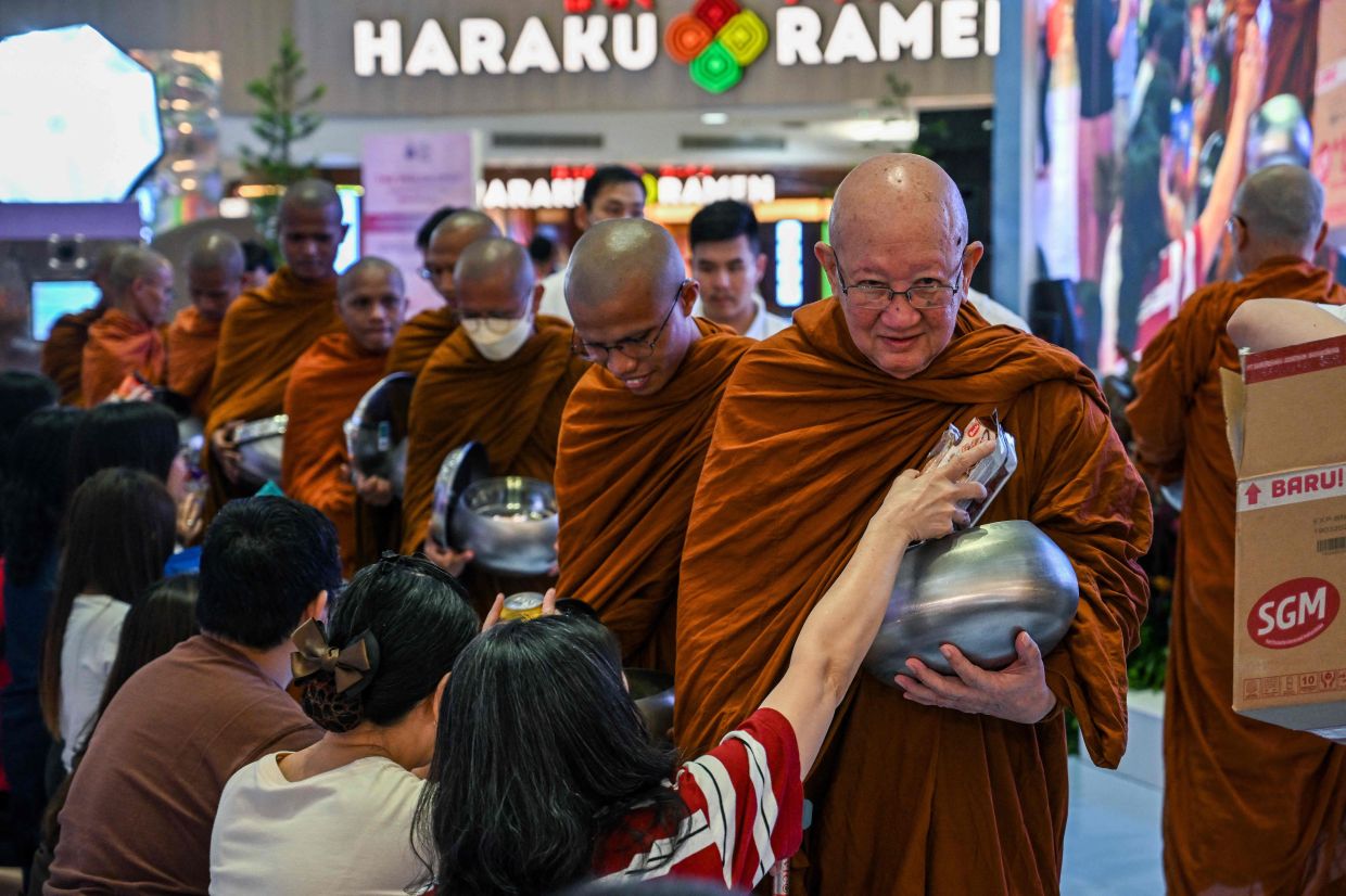 Buddhist monks receive alms from devotees at a shopping mall in Surabaya on Saturday, May 30, 2026, ahead of the Buddhist Vesak festival, also known as Buddha Jayanti (Wesak Day), that commemorates the birth, enlightenment, and death of Buddha. -- Photo by JUNI KRISWANTO / AFP