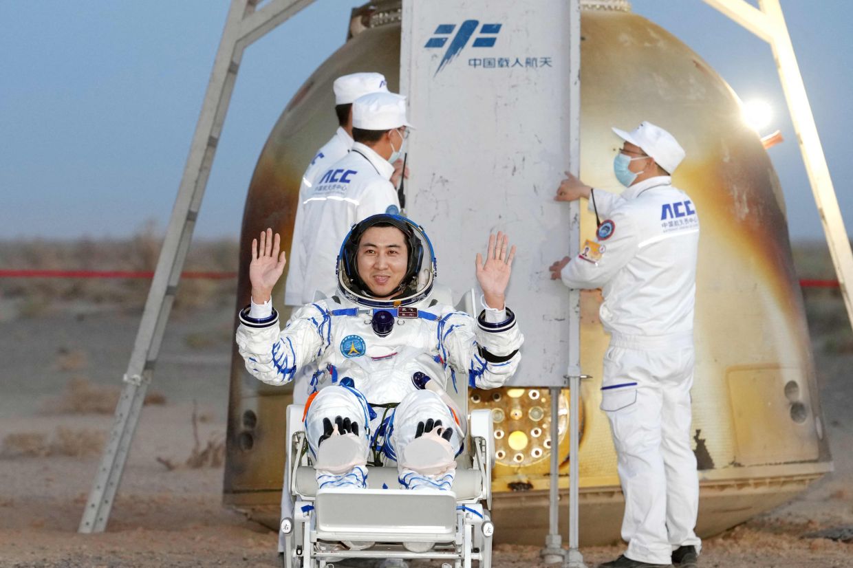 Shenzhou-21 astronaut Wu Fei waves after being carried from the Shenzhou-22 spacecraft after landing in China's northern Inner Mongolia region. China's Shenzhou-21 crew returned to Earth aboard the Shenzhou-22 spacecraft on May 29 after seven months in space. -- Photo by CNS / AFP) 