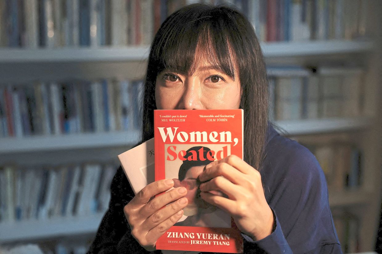 Author Zhang poses with copies of her book 'Women, Seated' in its original Chinese and in translation during an interview at her home in Beijing, China. Photo: Reuters 