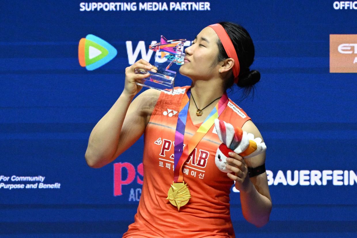 An Se-young of South Korea celebrates with the trophy after defeating Akane Yamaguchi of Japan in the women's singles final match of the KFF Singapore Open Badminton tournament in Singapore on Sunday, May 31, 2026. -- Photo by Roslan RAHMAN / AFP