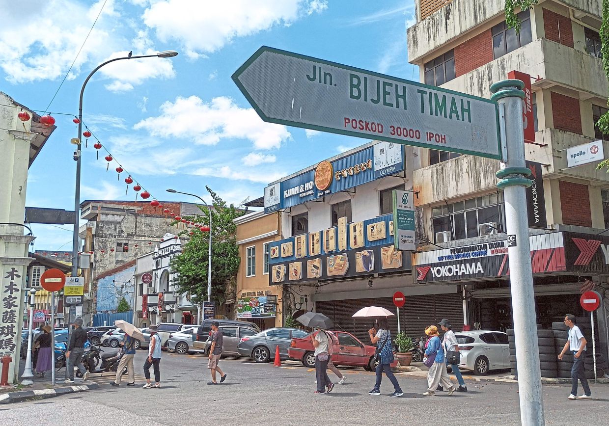 Visitors braving the hot sun in the tourist enclave of Ipoh Old Town.Below: Ipoh is full of interesting spots such as cafes with nostalgic decor (right) and Gerbang Malam night market (left).