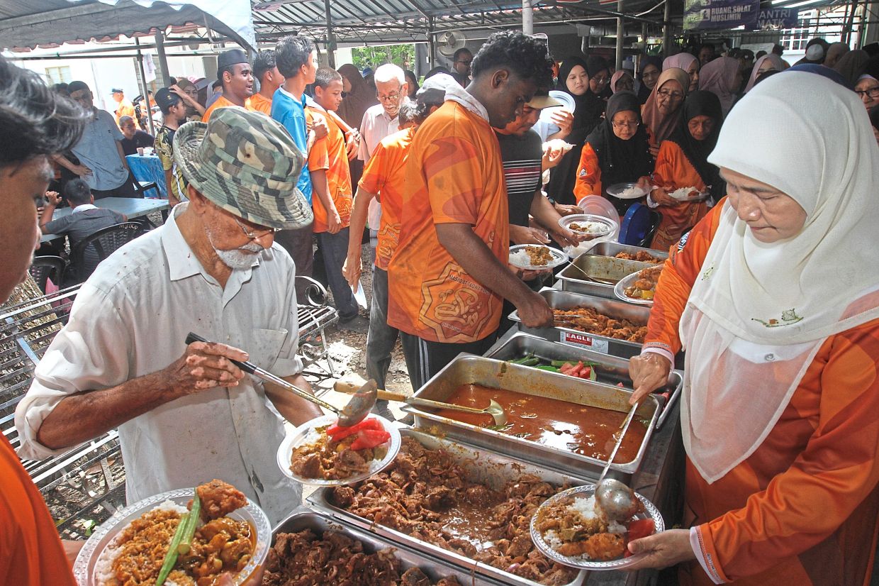 People enjoying the feast at the mosque.