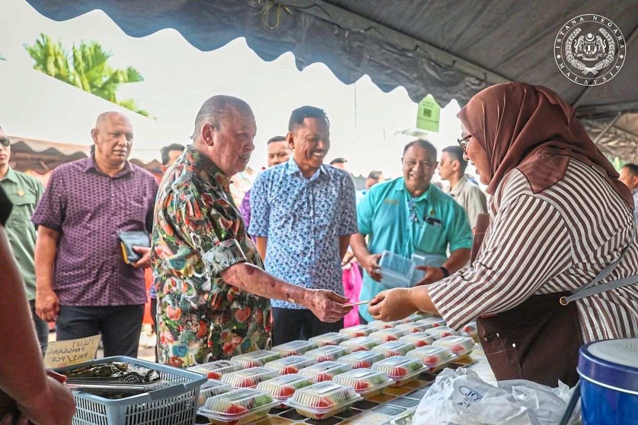 Sultan Ibrahim presenting a personal contribution to a stall operator at the Taman Lautan Biru Ramadan bazaar in Mersing, Johor, on March 7. 