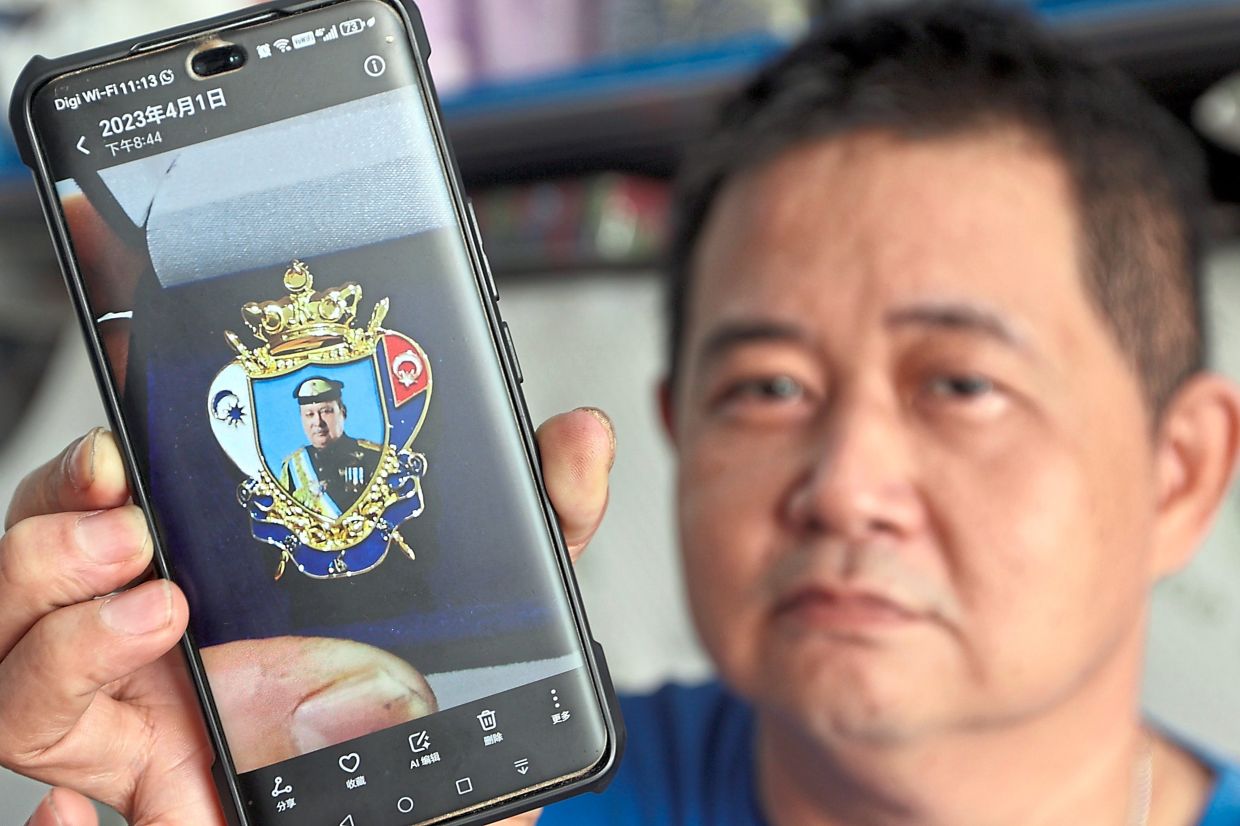 Yeow showing an image of a commemorative pin presented to him by Sultan Ibrahim.