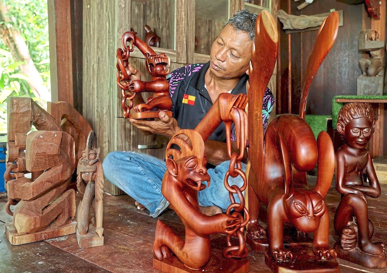 Samri showing some of his sculptures carved from ‘nyireh’ wood.