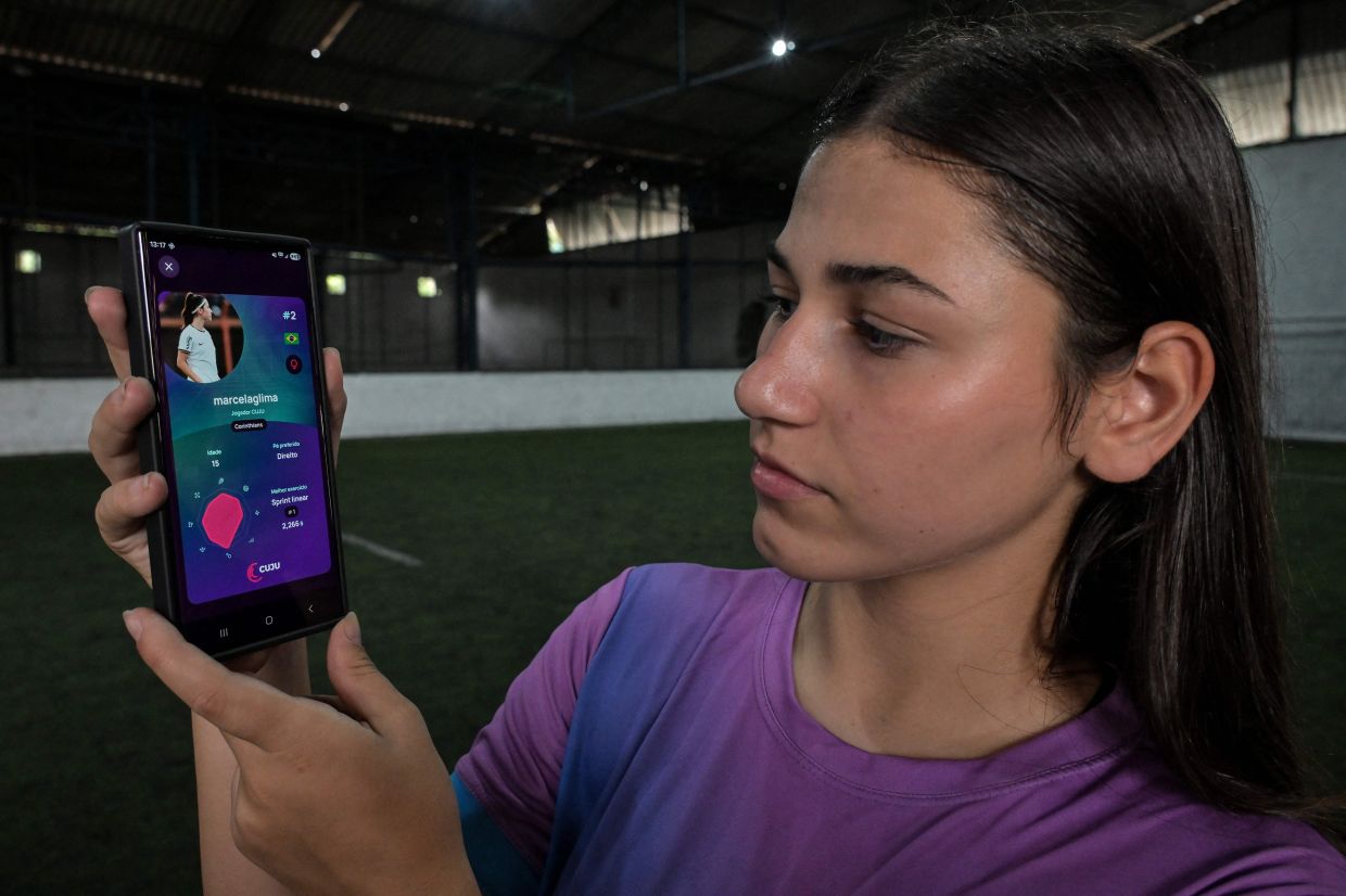 Brazilian football player Marcela Geremias de Lima shows herself on the screen of the Cuju app, in Sao Paulo, Brazil.