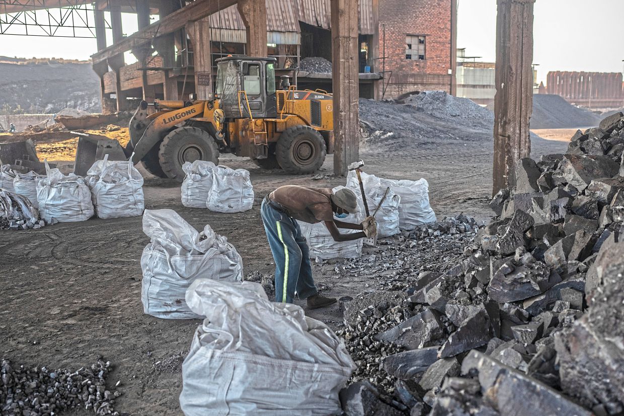 A man works with silicon manganese at the Chinese-owned Datong Processing plant in Kabwe, Zambia, on July 17, 2024. Some analysts say that the Trump administration has used foreign aid to try to pressure Zambia to provide greater mining access. — Joao Silva/The New York Times