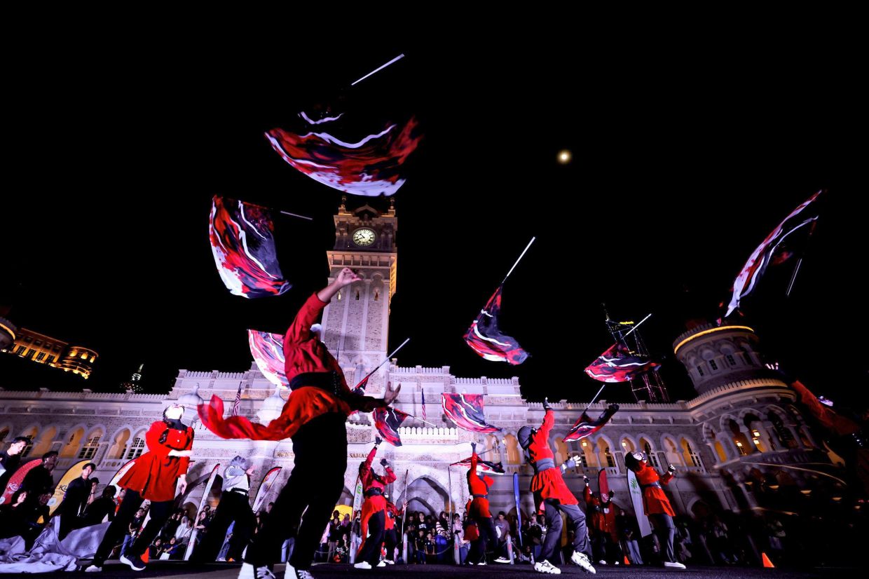 Colour guards performing in sync with school marching bands, creating an electrifying atmosphere at the close of KL Fest and launch of AMG at Dataran Merdeka. — Bernama