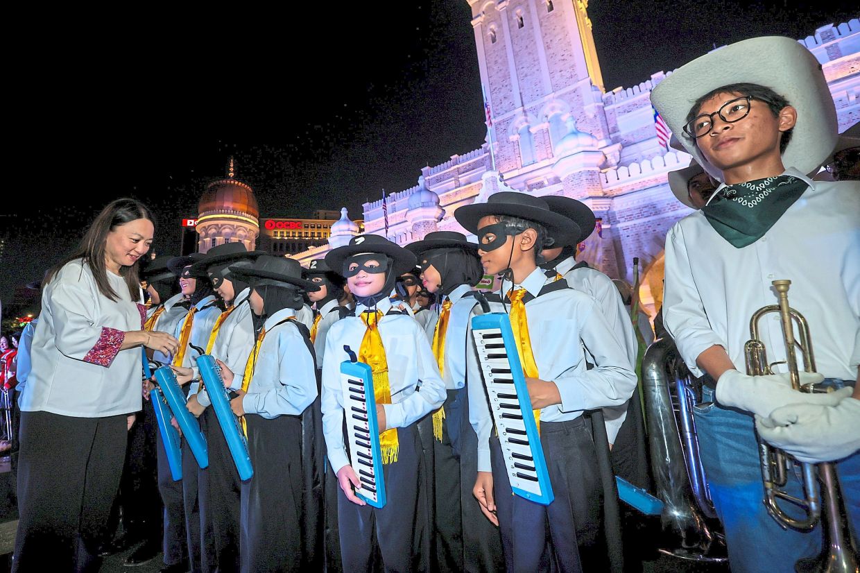 Yeoh (left) greeting marching band members at Dataran Merdeka. — Bernama