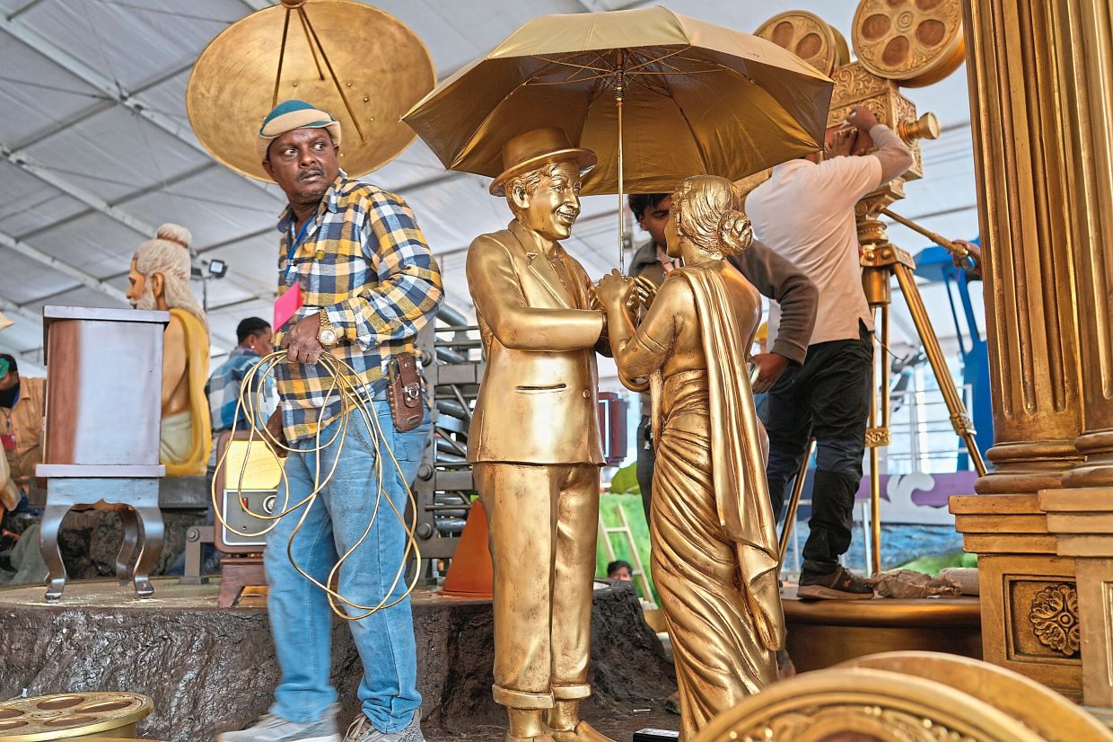 Gilded age: An artist giving a final look at the Indian Information and Broadcasting Ministry’s tableaux showcasing phases of Bollywood ahead of Republic Day celebrations on Jan 26, in New Delhi. — AP