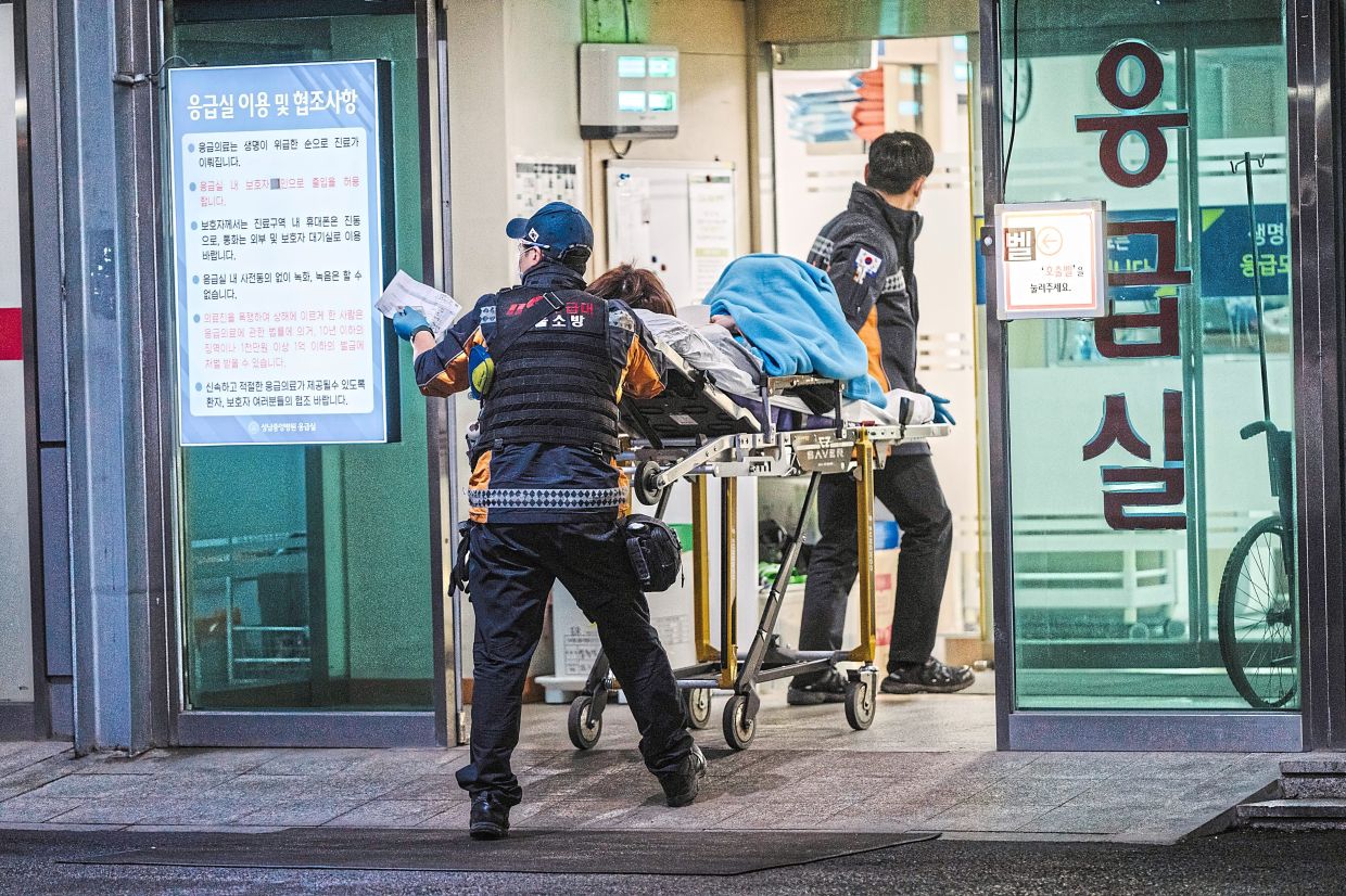 Emergency workers bringing a patient into the ER of a hospital in Seongnam. Representative Yang is pushing to amend the law to give paramedics the authority to designate hospitals for emergency patients. — Jun Michael Park/The New York Times 
