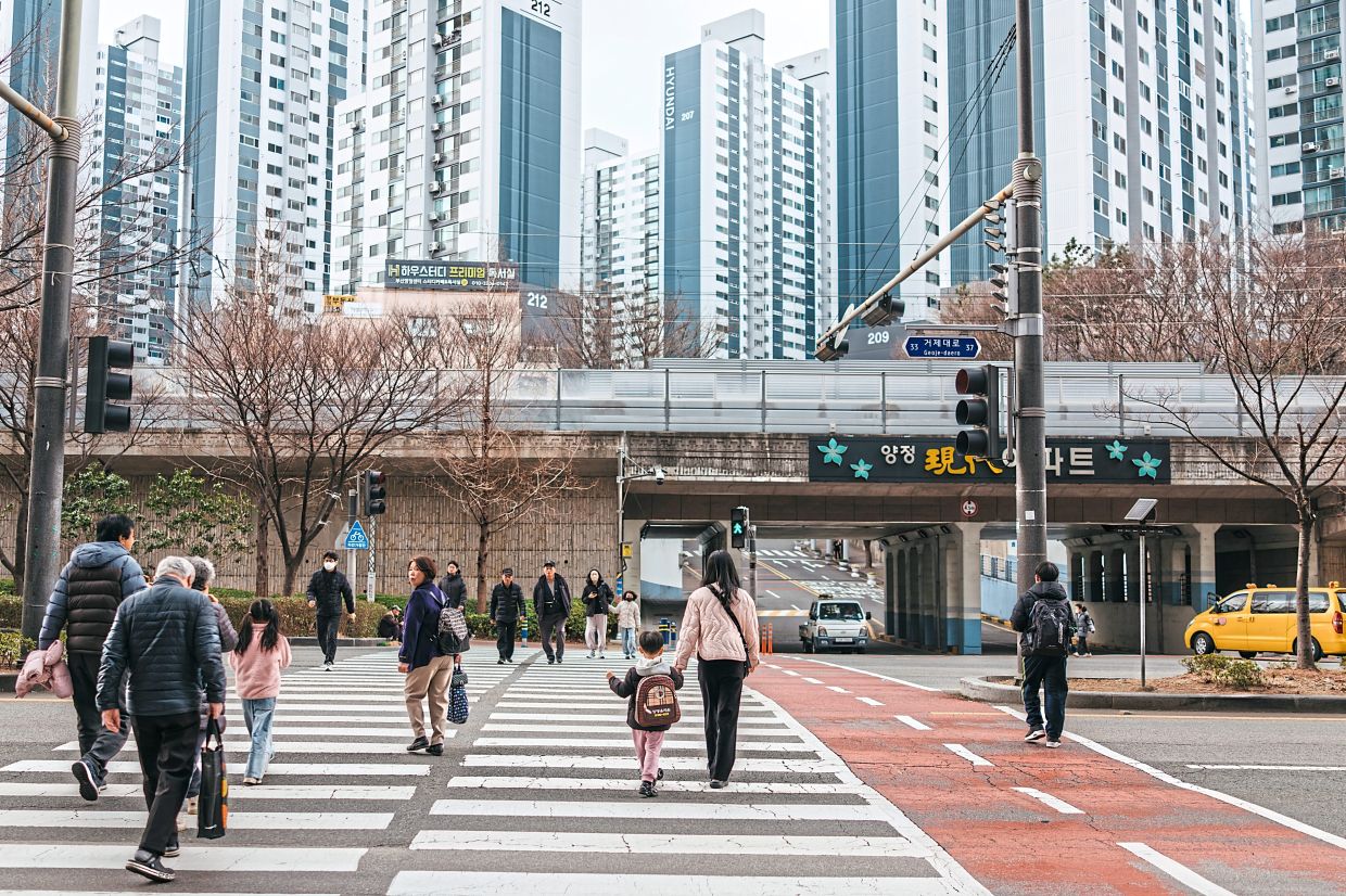 So-hee (centre) walking home with her younger son in Busan, South Korea. Hundreds of patients every year have trouble finding emergency care, even though South Korea has a world-class medical system. For some, the delays have been fatal. — Jun Michael Park/The New York Times 