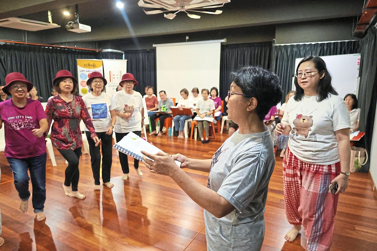 Teh (far right) observing the performers rehearse a scene.