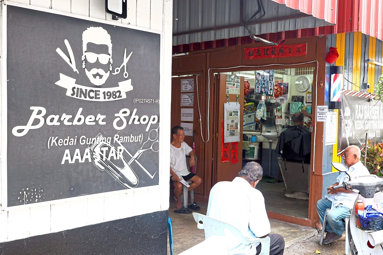Regulars wait to have their hair cut by Selvaraj at his family’s century-old barber shop in Ipoh’s Old Town.