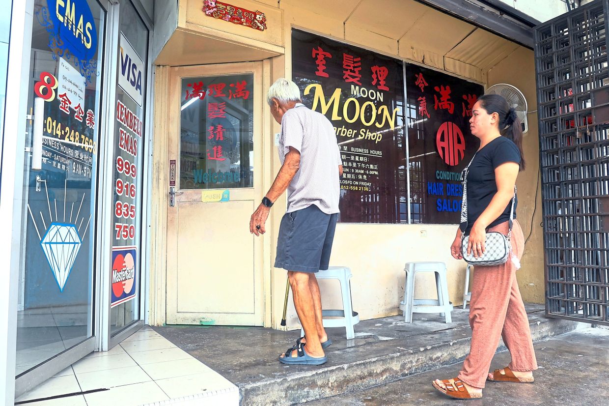 Customers entering the Moon Moon Barber Shop in Ipoh Garden.