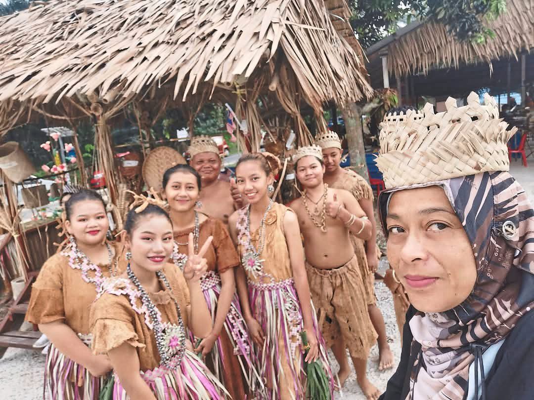 Azlina interacting with an Orang Asli community, an experience that allowed her to learn more about different cultures throughout her career.
