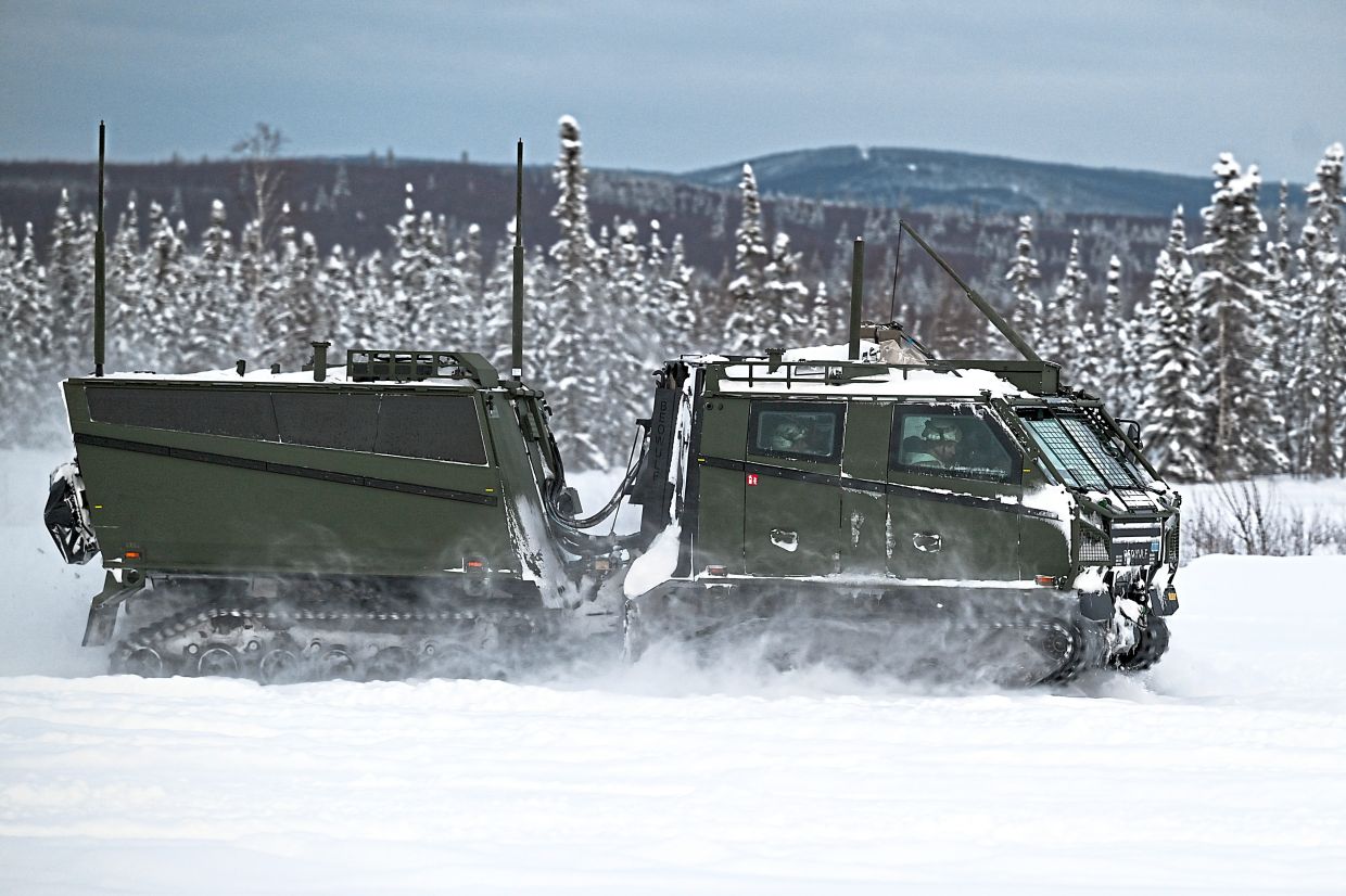 A Swedish-made arctic vehicle, which can carry a dozen soldiers, swiftly travels through deep snow during military exercises. — Kenny Holston/The New York Times