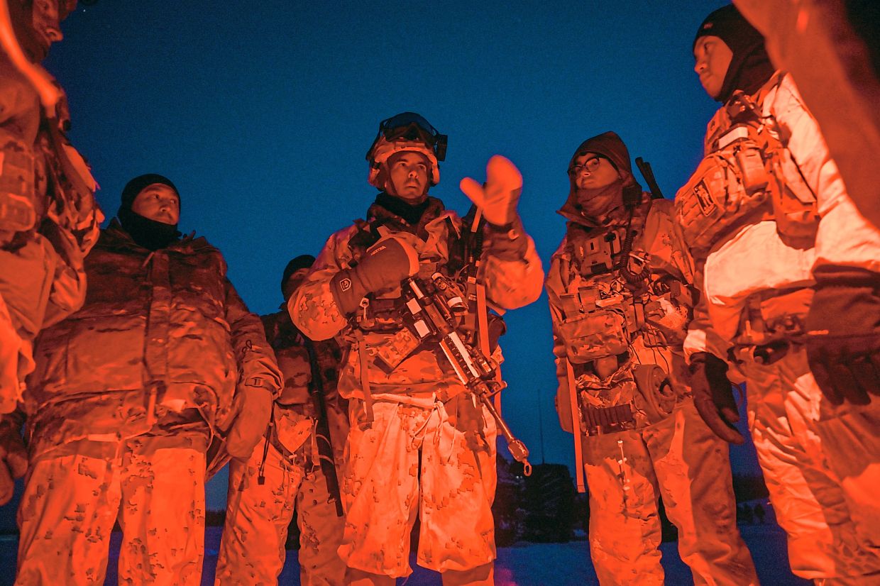 Col Brawley (centre), briefing soldiers before night operations at the Yukon Training Centre near Fairbanks, Alaska. — Kenny Holston/The New York Times