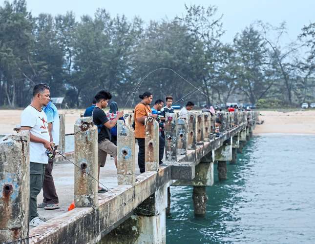 Anglers gathering at Pantai Awana jetty in the evening to catch squid.