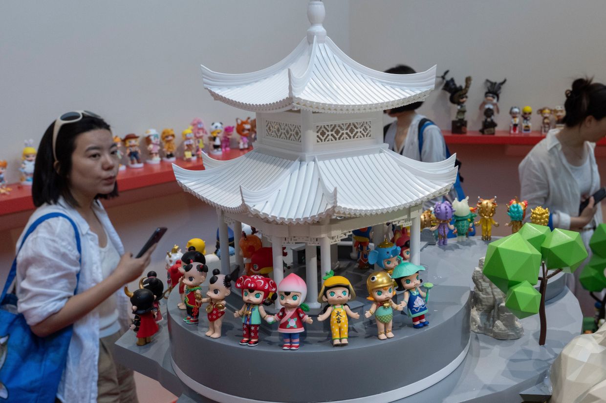 A visitor attends a media preview of the Molly 20th anniversary exhibition from Chinese collectible company Pop Mart in Beijing. -- AP Photo/Ng Han Guan
